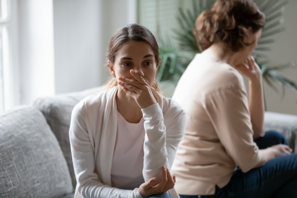 A young woman and an older one sitting with their backs turned against each other | Source: Shutterstock