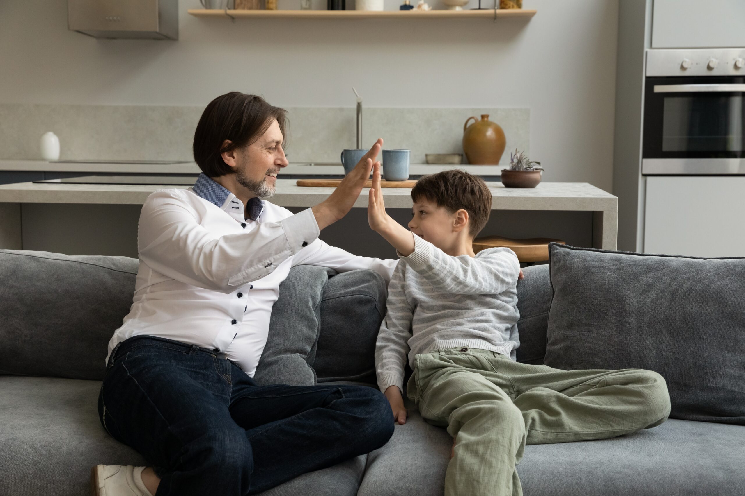 A man giving a high five to a young boy | Source: Shutterstock