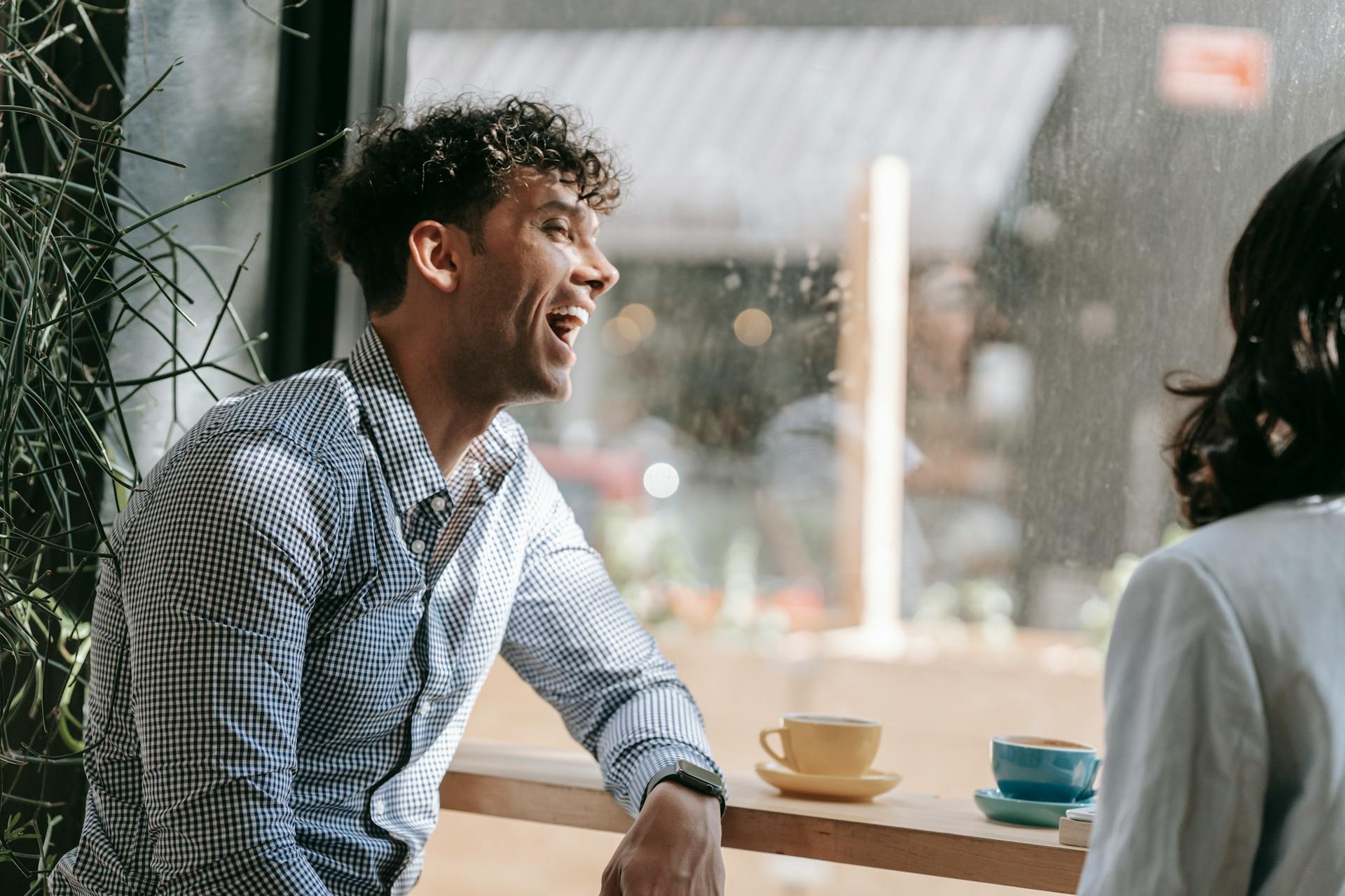 A man laughing in a coffee shop | Source: Pexels