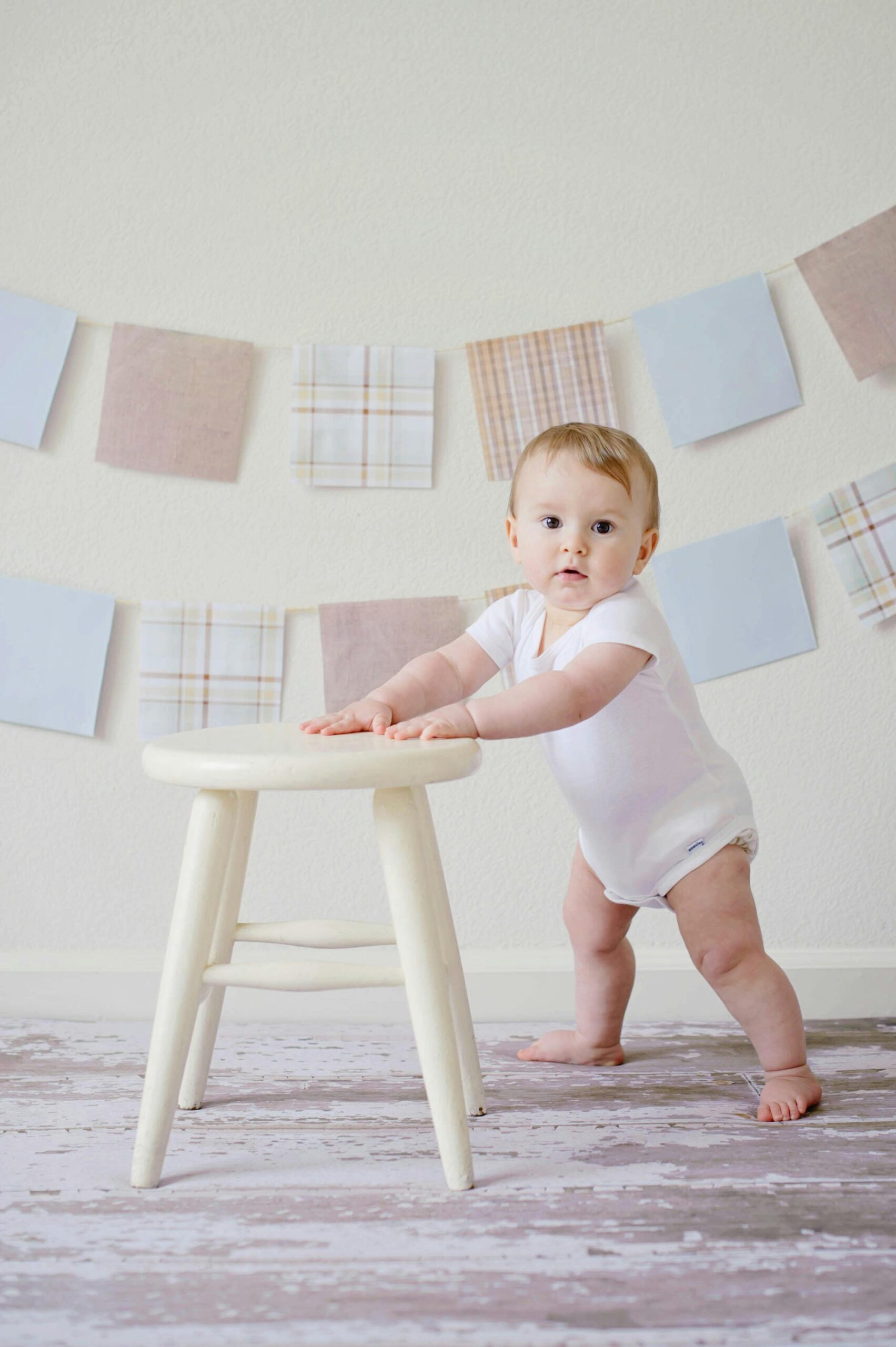 A baby learning to stand with the help of a stool | Source: Pexels