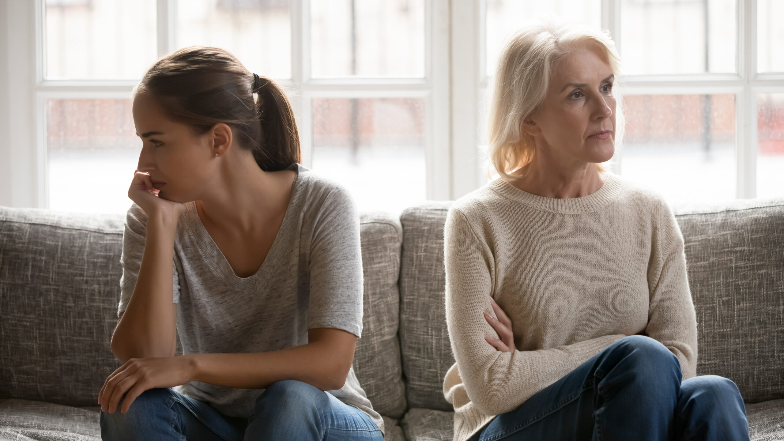 A mother and daughter sitting on a sofa after a fight | Source: Shutterstock