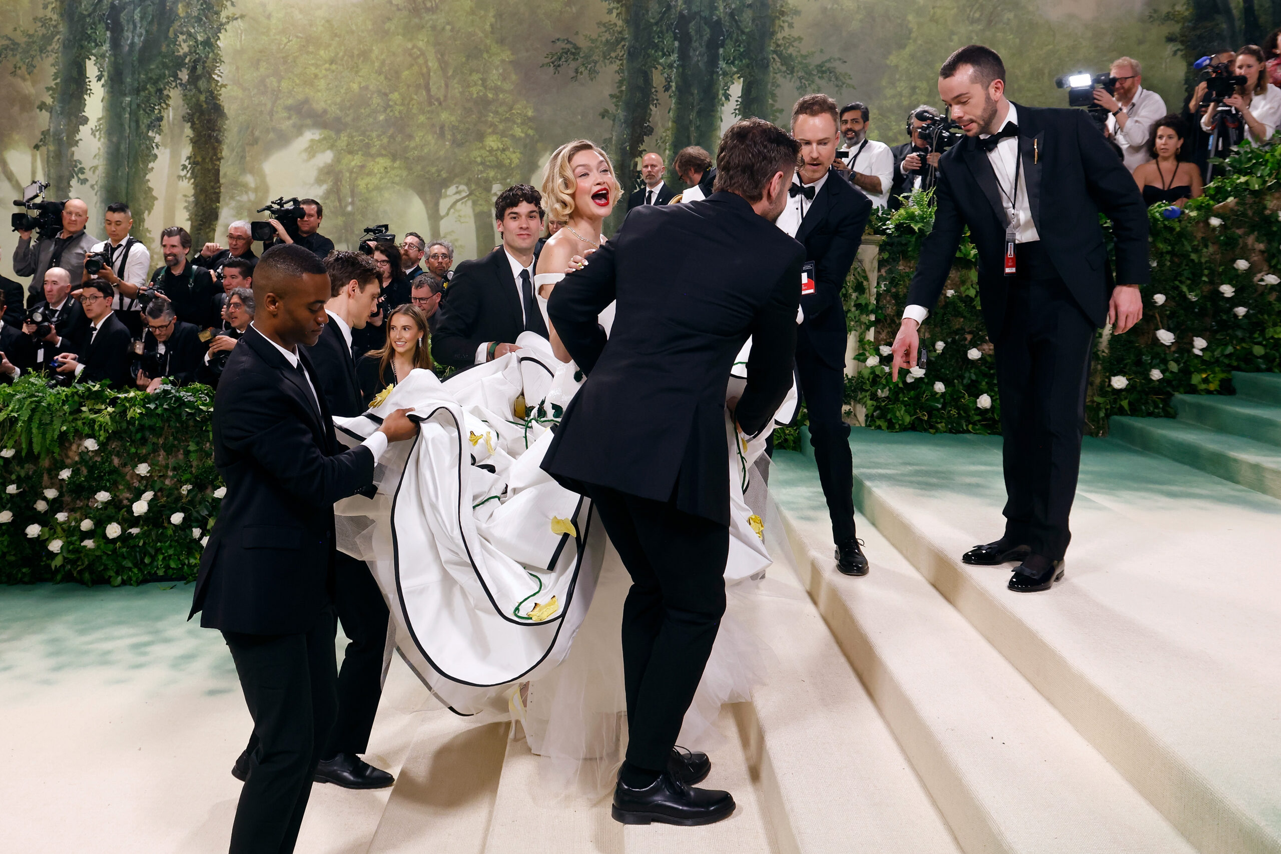 Gigi Hadid with people helping her walk up the stairs at the 2024 Met Gala in New York | Source: Getty Images