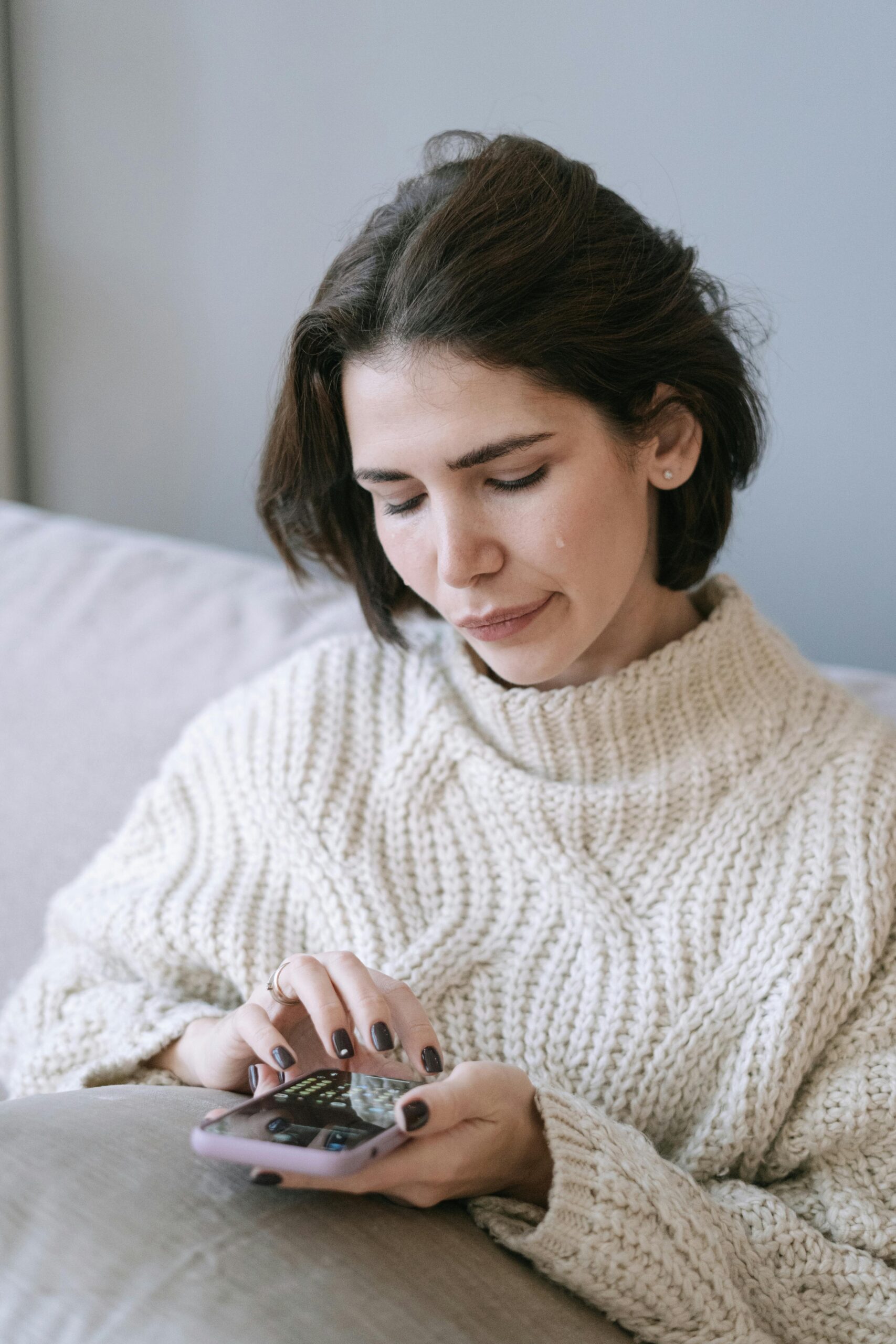 A woman crying and pleading while holding a phone | Source: Pexels