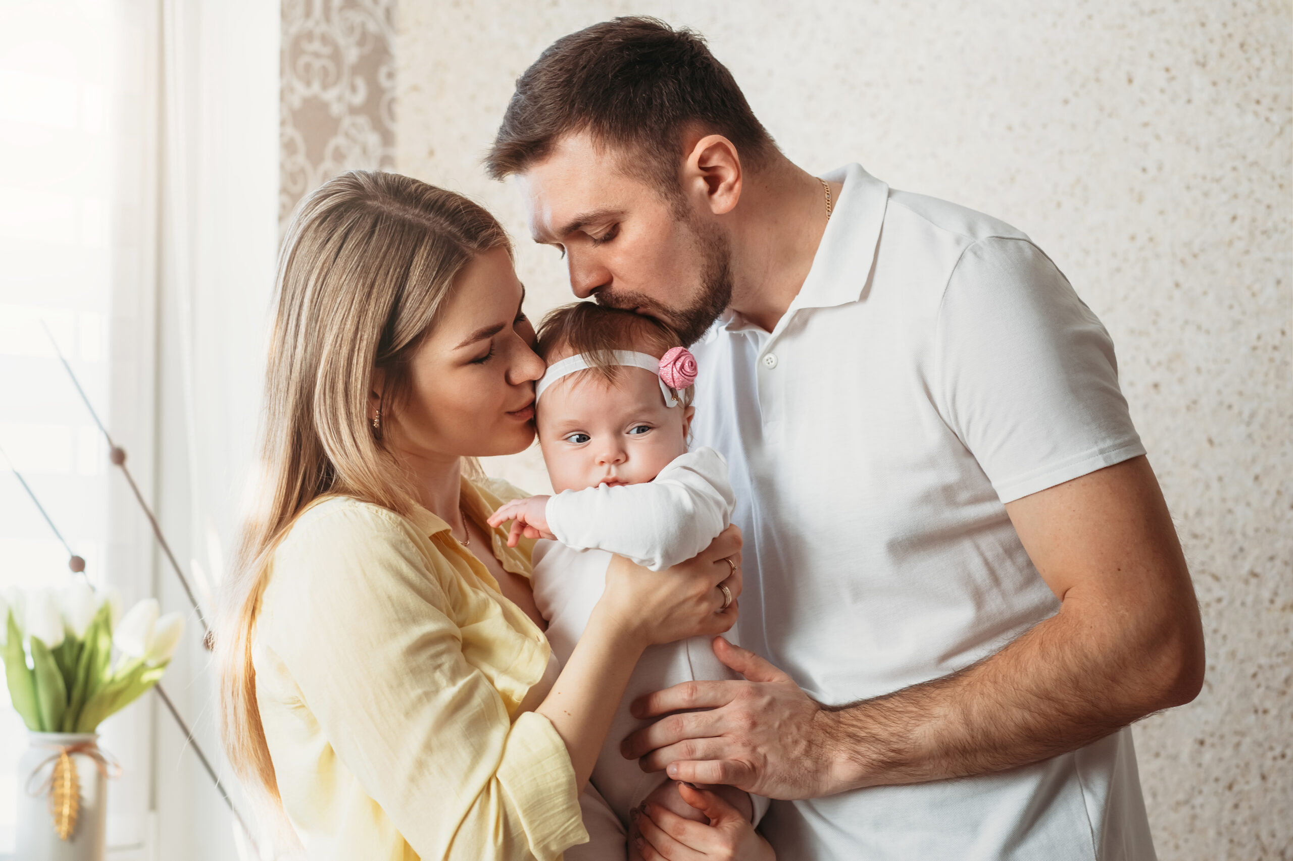 A couple kissing their baby girl | Source: Shutterstock