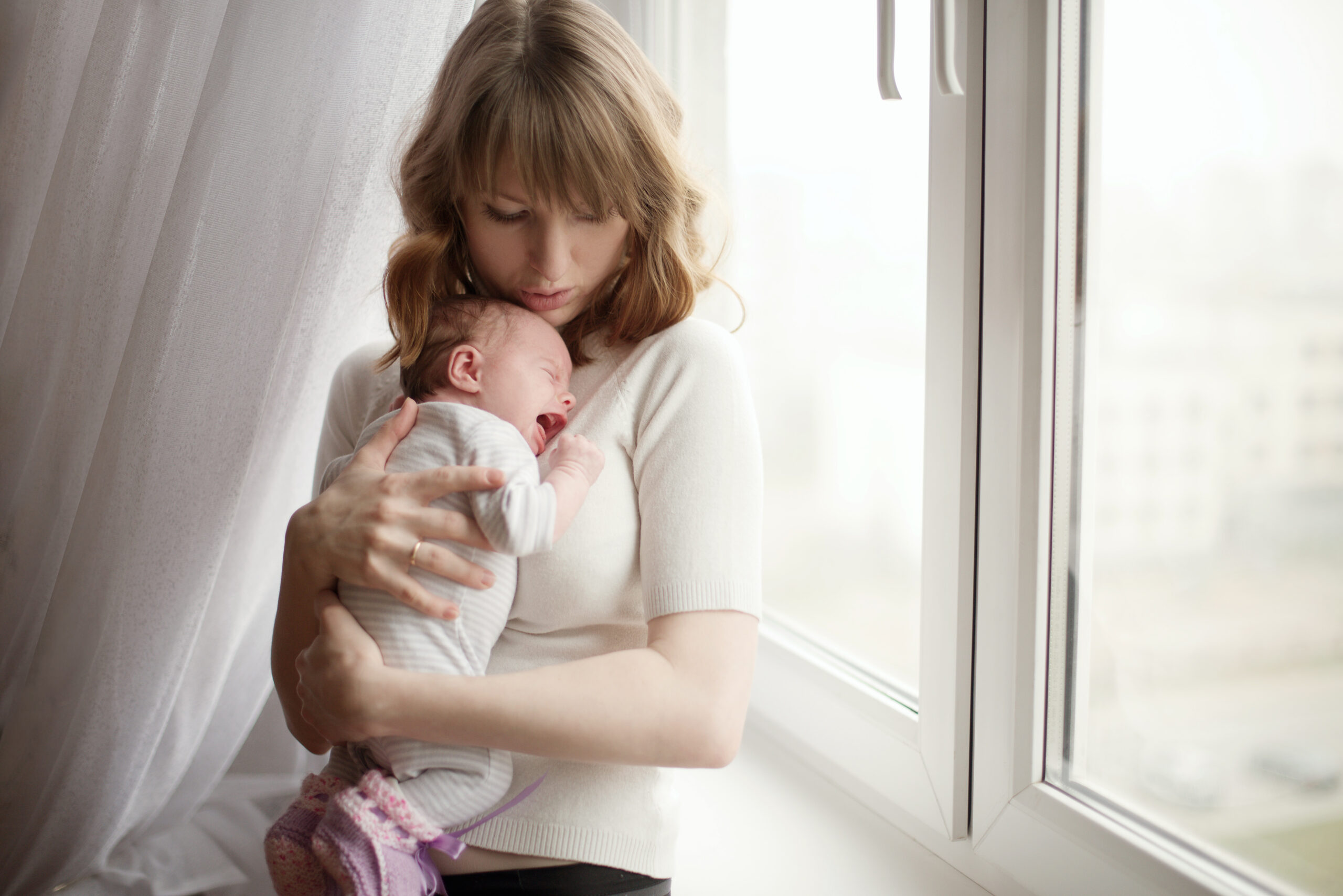 A mother trying to calm her crying baby | Source: Shutterstock