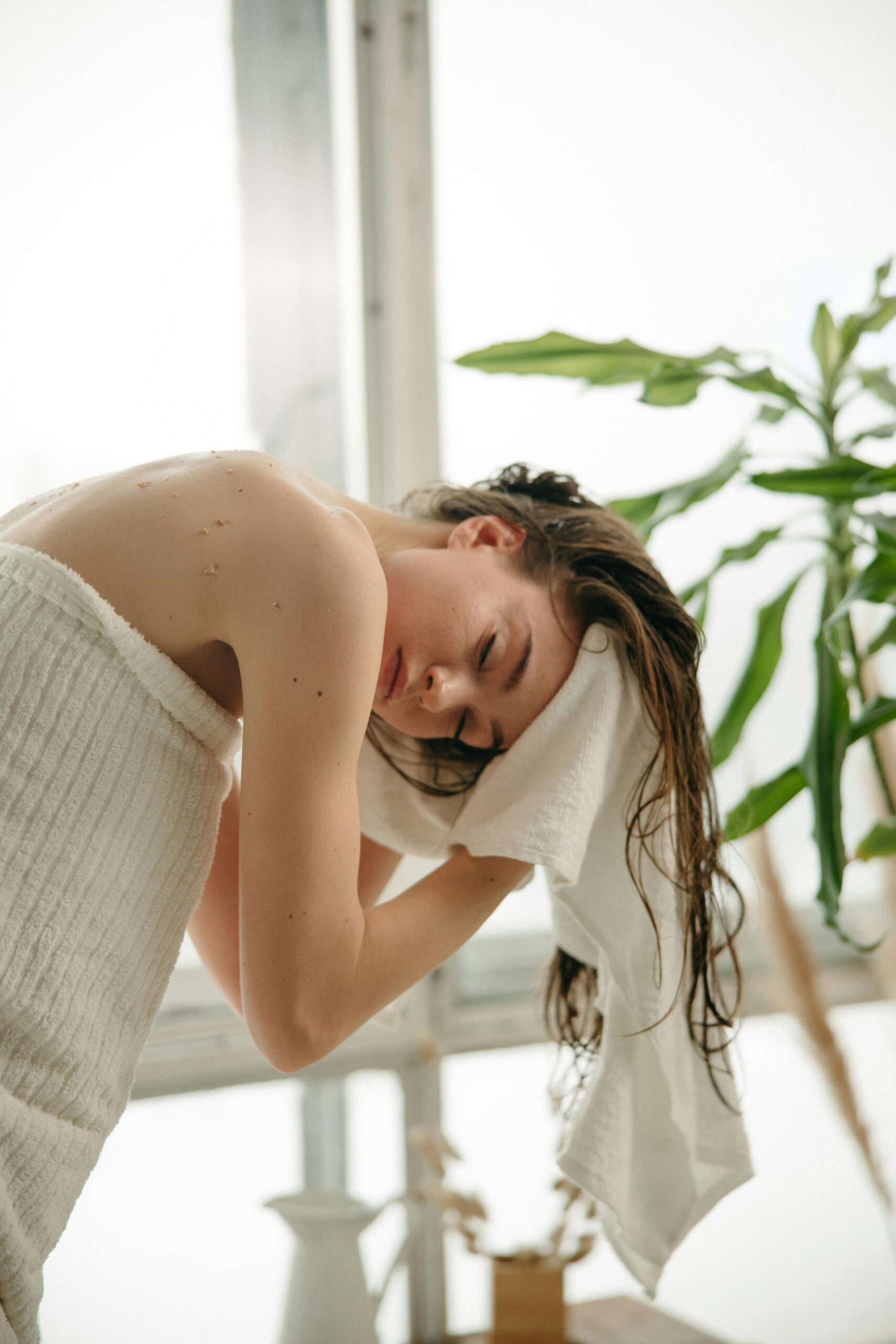 A woman towel drying her hair after a shower | Source: Pexels