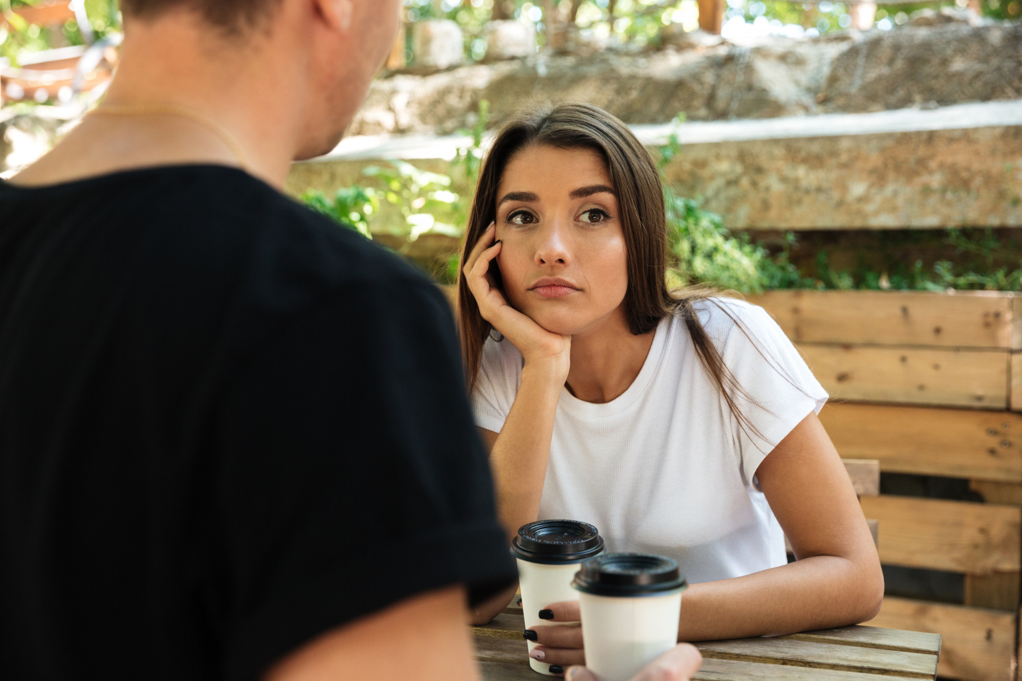 A bored and annoyed-looking woman listening to a man talk | Source: Freepik