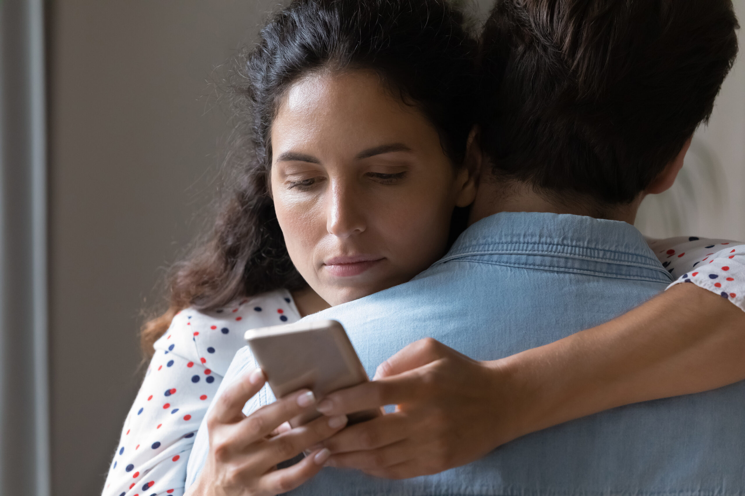 A woman talking to another person behind her lover's back | Source: Getty Images