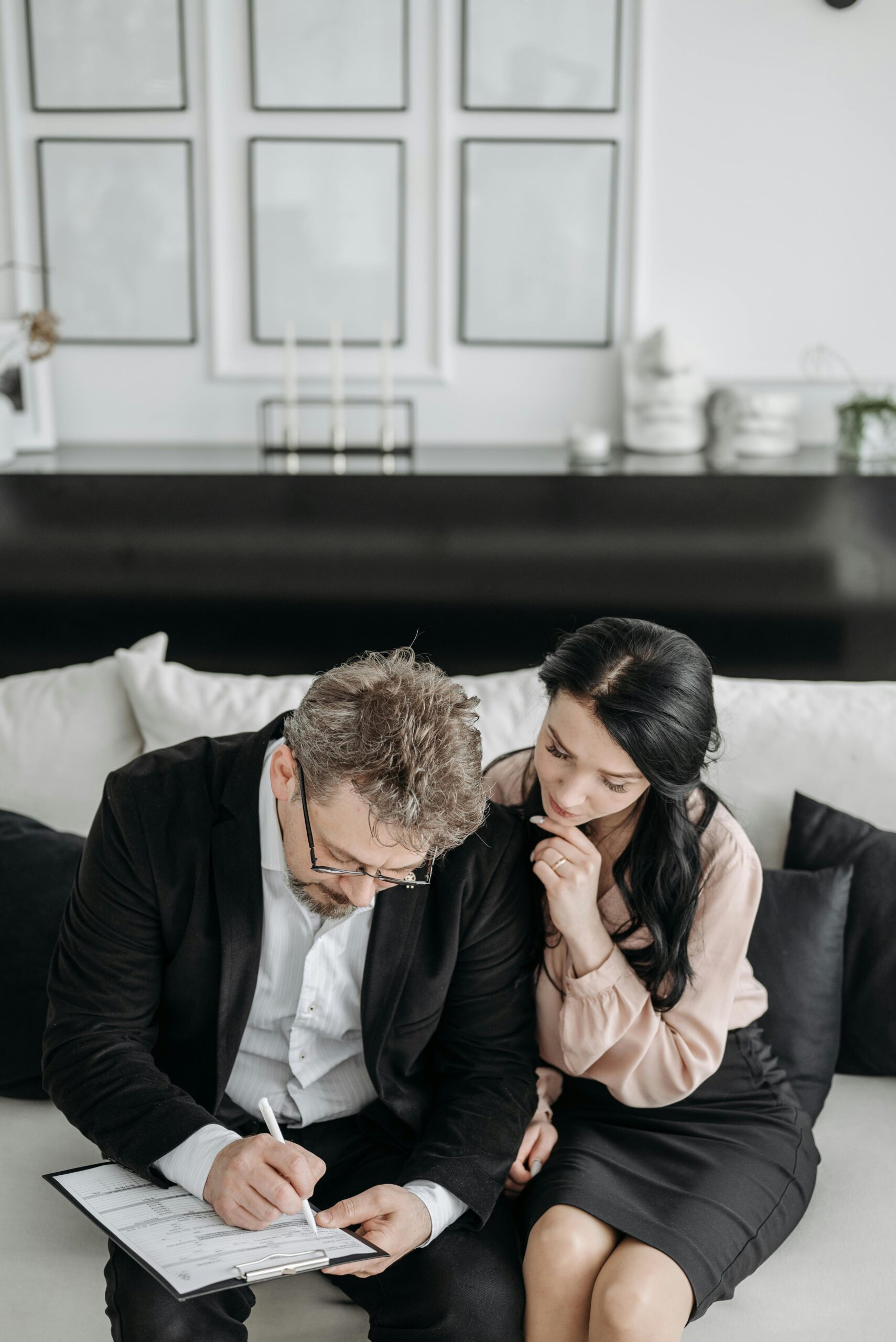 A man filling out an adoption form with his wife | Source: Pexels