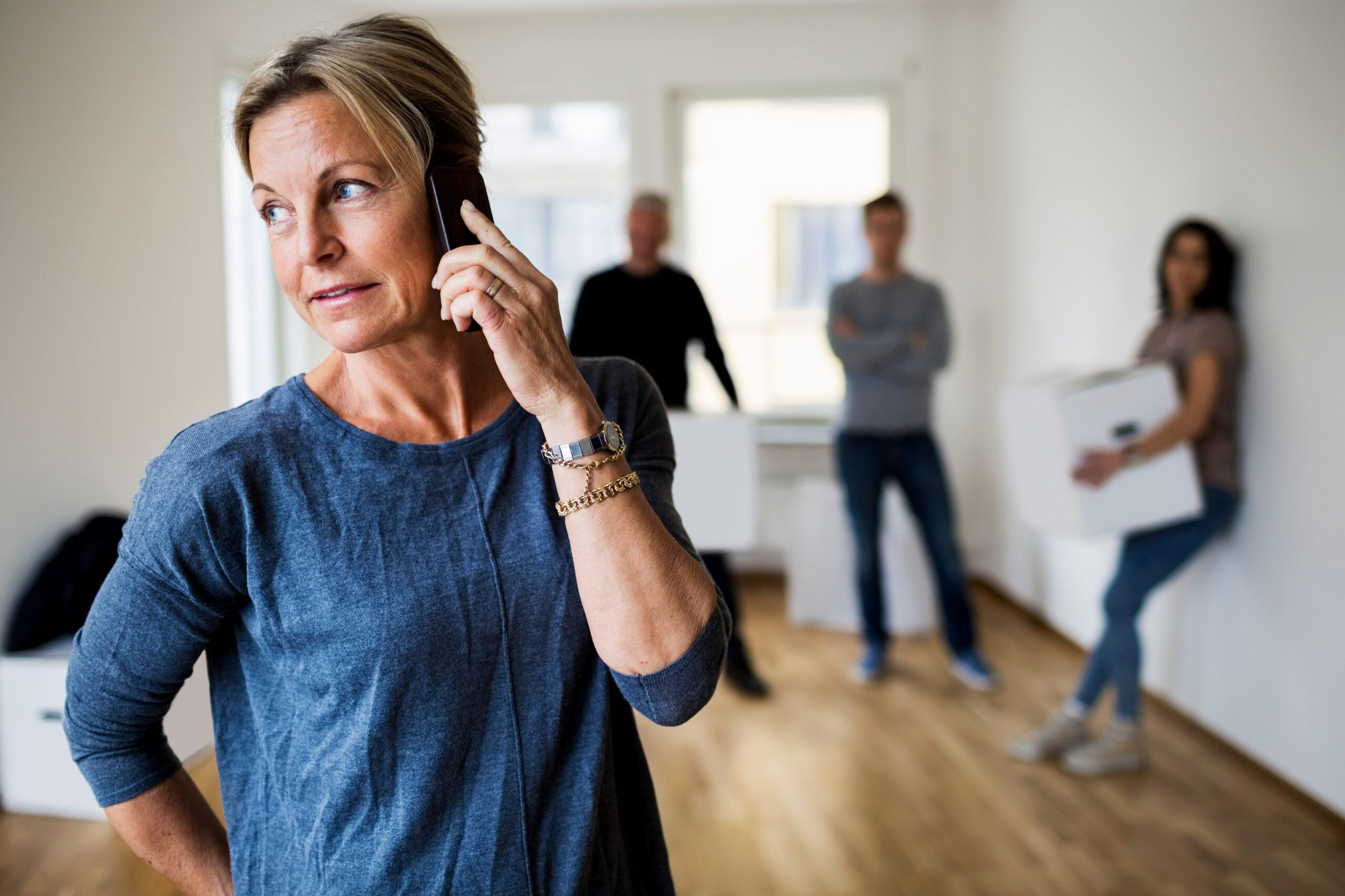 A woman talking on the phone while people are behind her. | Source: Getty Images