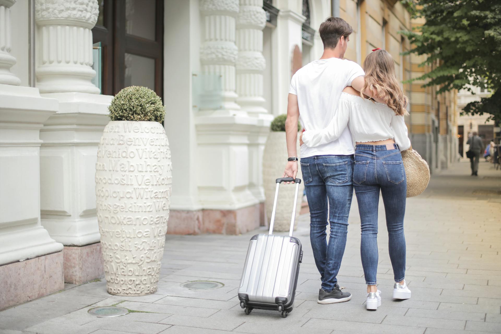 Couple with a suitcase walking on the street | Source: Pexels