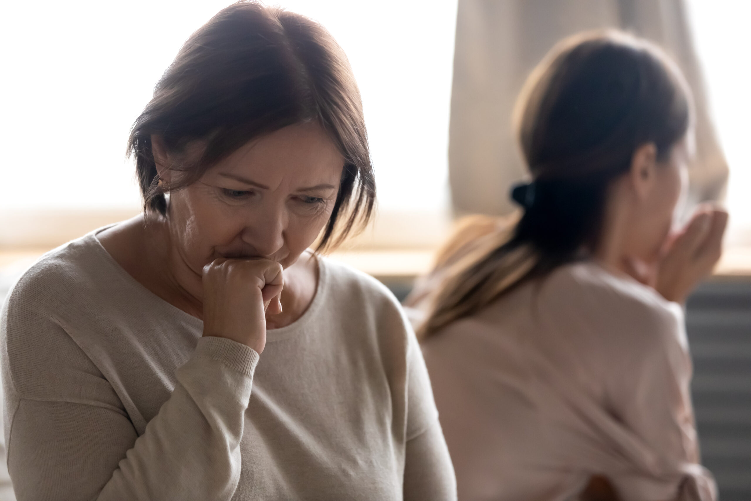 An older woman, on the verge of tears, is sitting with her daughter | Source: Shutterstock