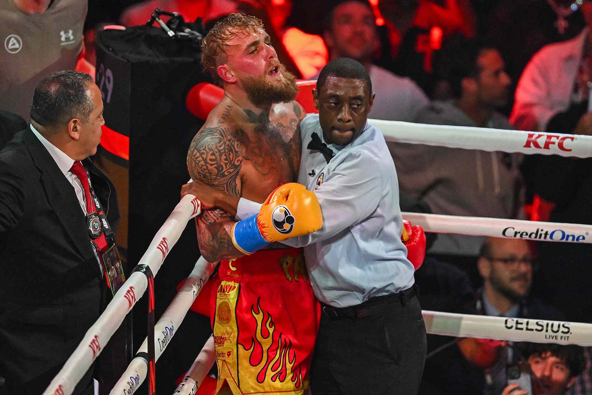 Referee Christopher Young holds US boxer and influencer Jake Paul against the ropes during his fight against British boxer Anthony Joshua (off frame) in a non-title heavyweight bout at the Kaseya Center in Miami, Florida, on December 19, 2025.