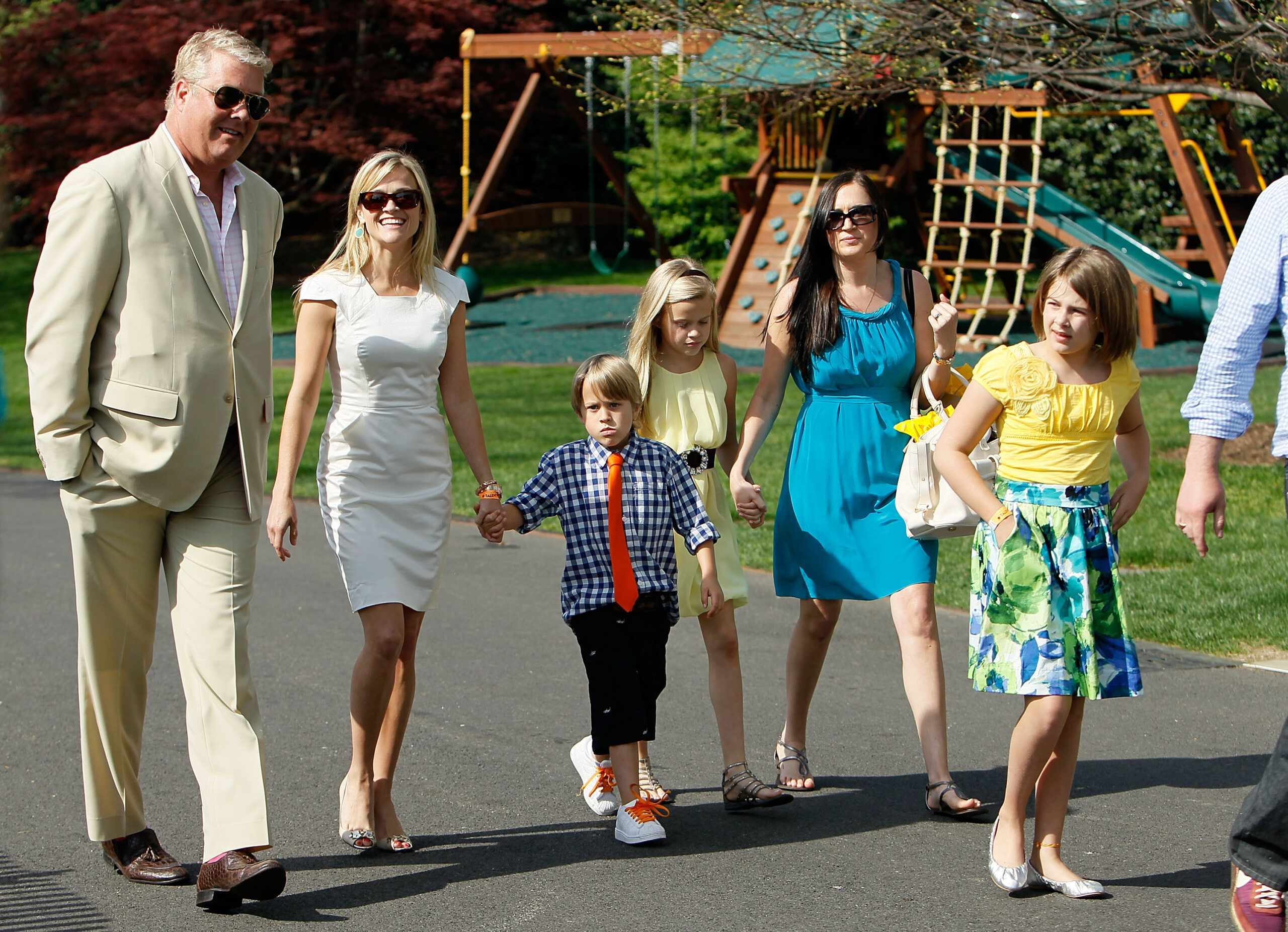 Reese Witherspoon walks across the South Lawn with Deacon Reese Phillippe, Ava Elizabeth Phillippe, and others at the White House Easter Egg Roll, a tradition dating back to 1878.