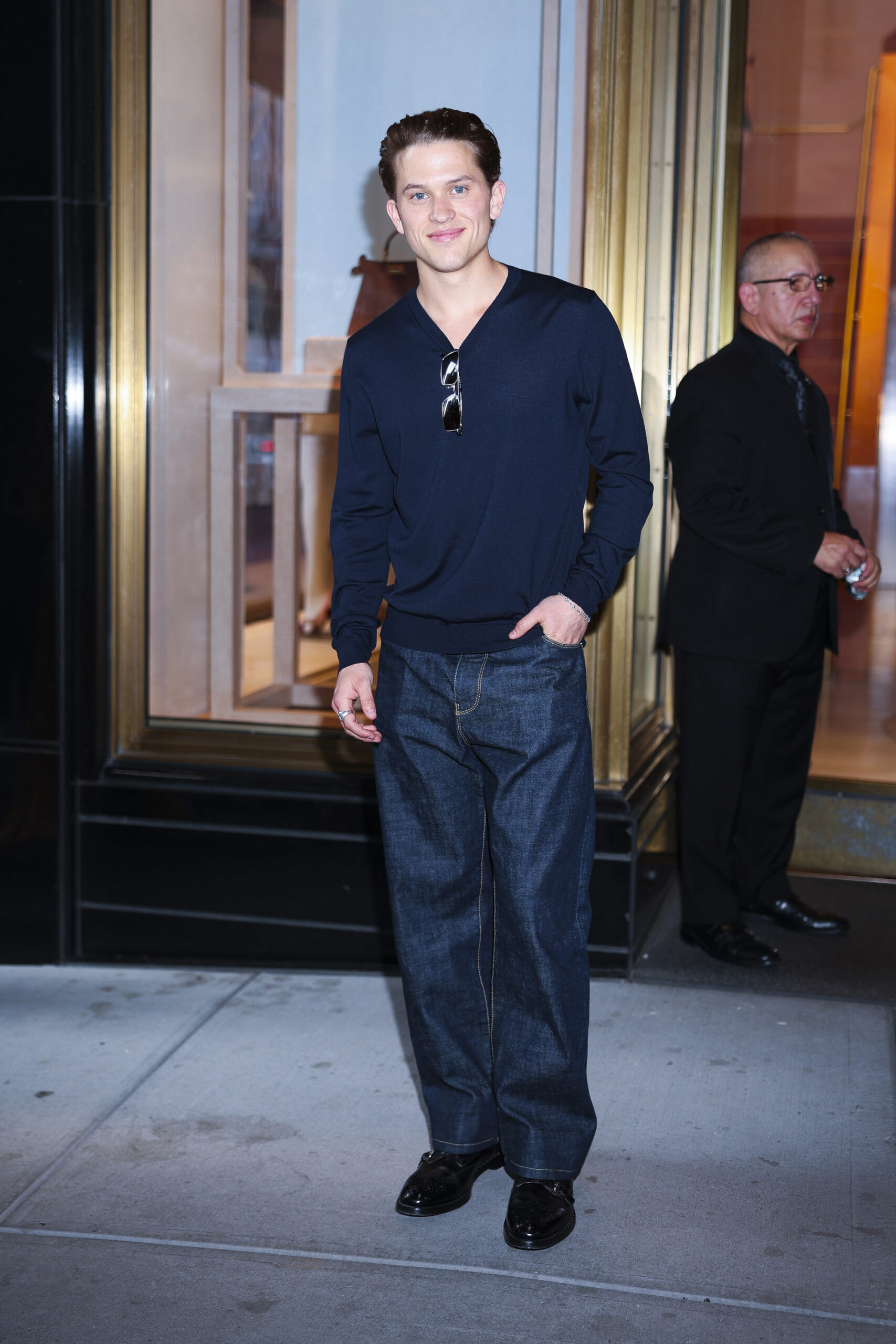 Deacon Reese Phillippe attends Fendi's Baguette 26424 Re-Edition event in Midtown New York City, wearing a dark sweater, wide-leg jeans, and glossy black shoes.