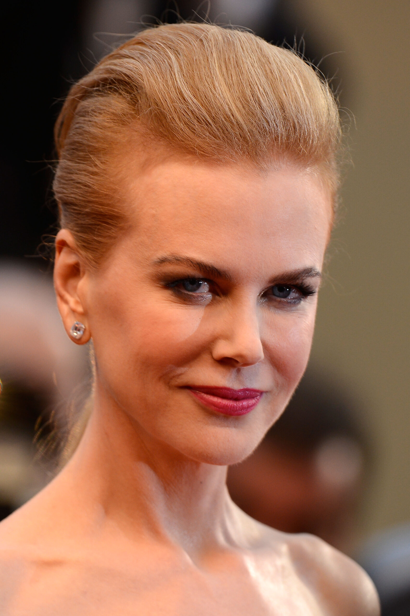 Sporting an edgy, high-volume pompadour updo at "The Great Gatsby" Cannes premiere in May 2013, her styling opted for a sharp, high-fashion vibe. With her hair pulled completely back, her face showed a return to natural expressions, featuring visible crinkling around the eyes and a relaxed, unforced smile.