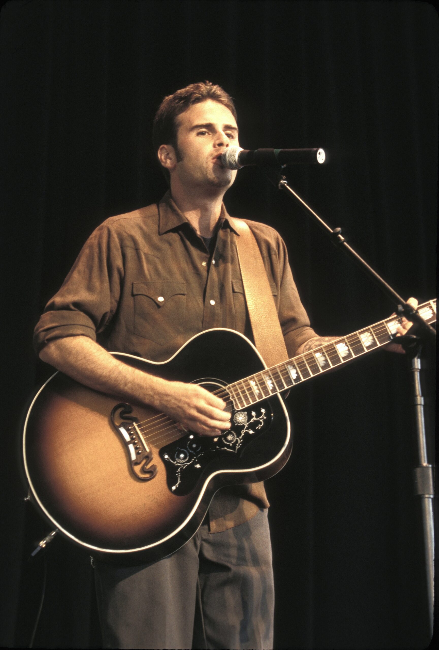 The former star performs with a guitar years after first picking up the instrument at age 12. The future actor once said music—not acting—was always his first love.