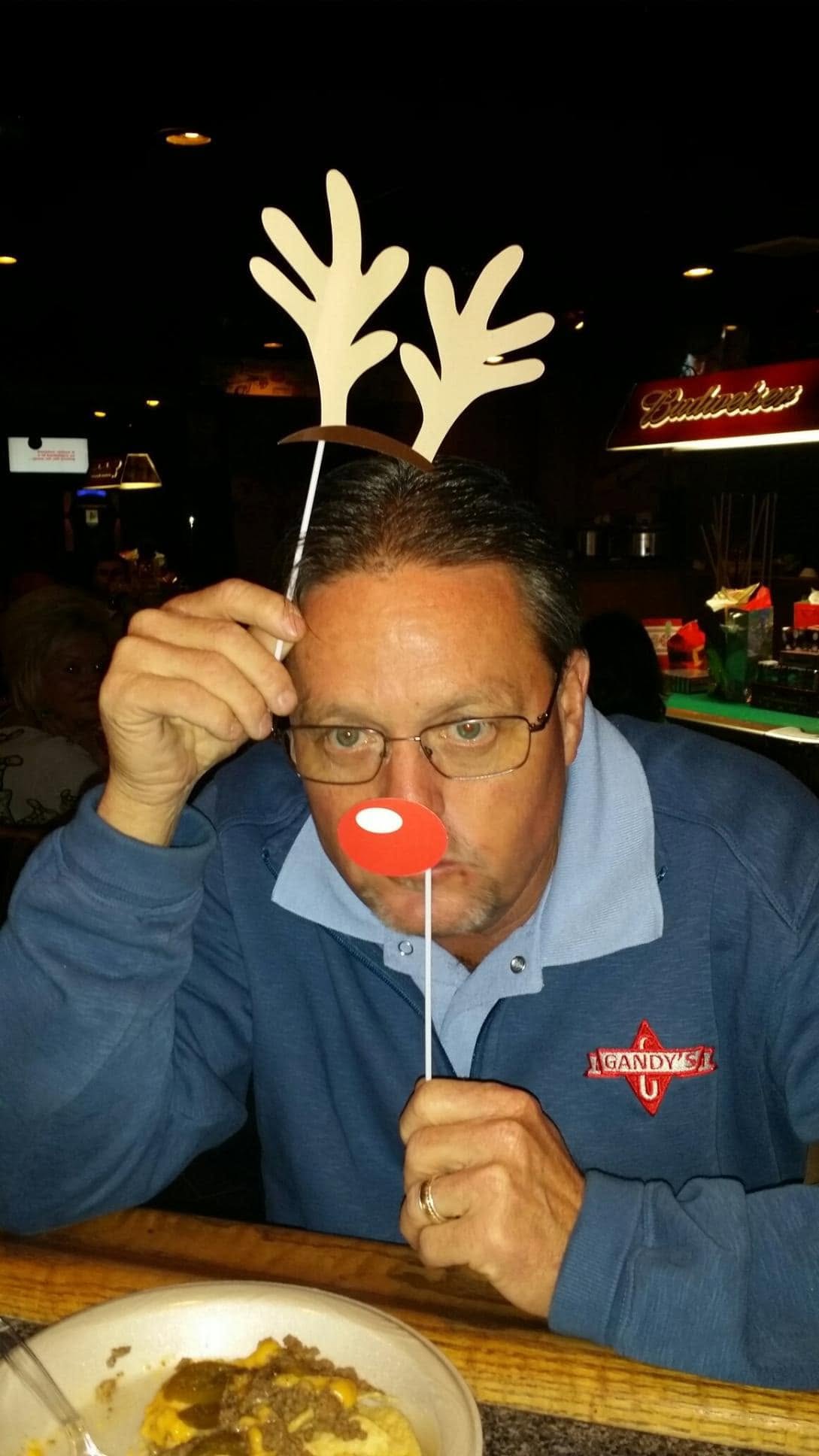 Ed Scott was remembered for his lighthearted spirit and deep ties to community athletics. On this occasion, he posed at a restaurant for a photo shared during an anniversary celebration on January 14, 2025.