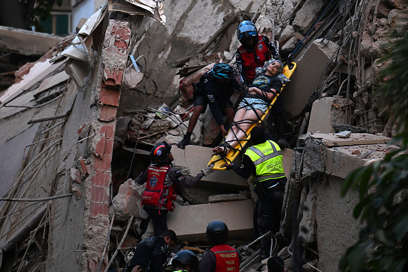 Emergency responders evacuate an injured person on a stretcher from the debris of a collapsed building after an earthquake struck Caracas, Venezuela, on June 24, 2026.