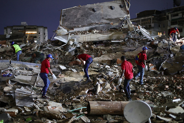 Rescue workers search through the rubble of a collapsed building for victims in the San Bernardino neighborhood after a magnitude 7.2 earthquake struck Venezuela and other parts of the Caribbean on June 24, 2026, in Caracas, Venezuela.