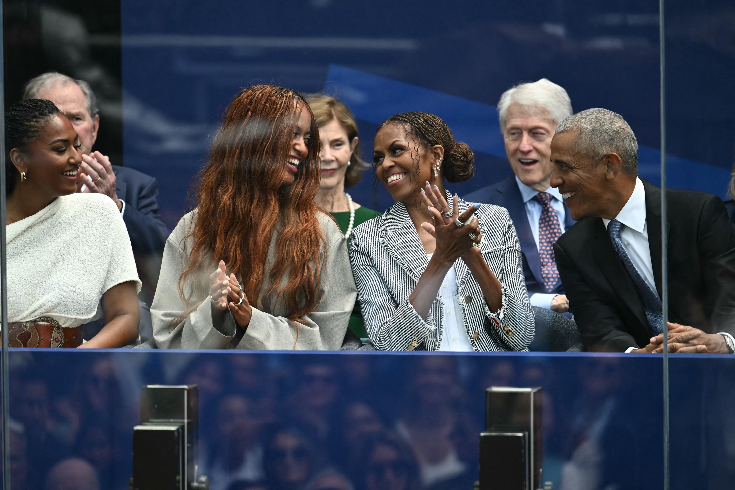 At one point, Malia Obama used her long hair to cover up as she walked alongside her family at the high-profile gathering. In this photo, the family is seen sitting together during the opening of the Barack Obama Presidential Center in Chicago, Illinois, on June 18, 2026.