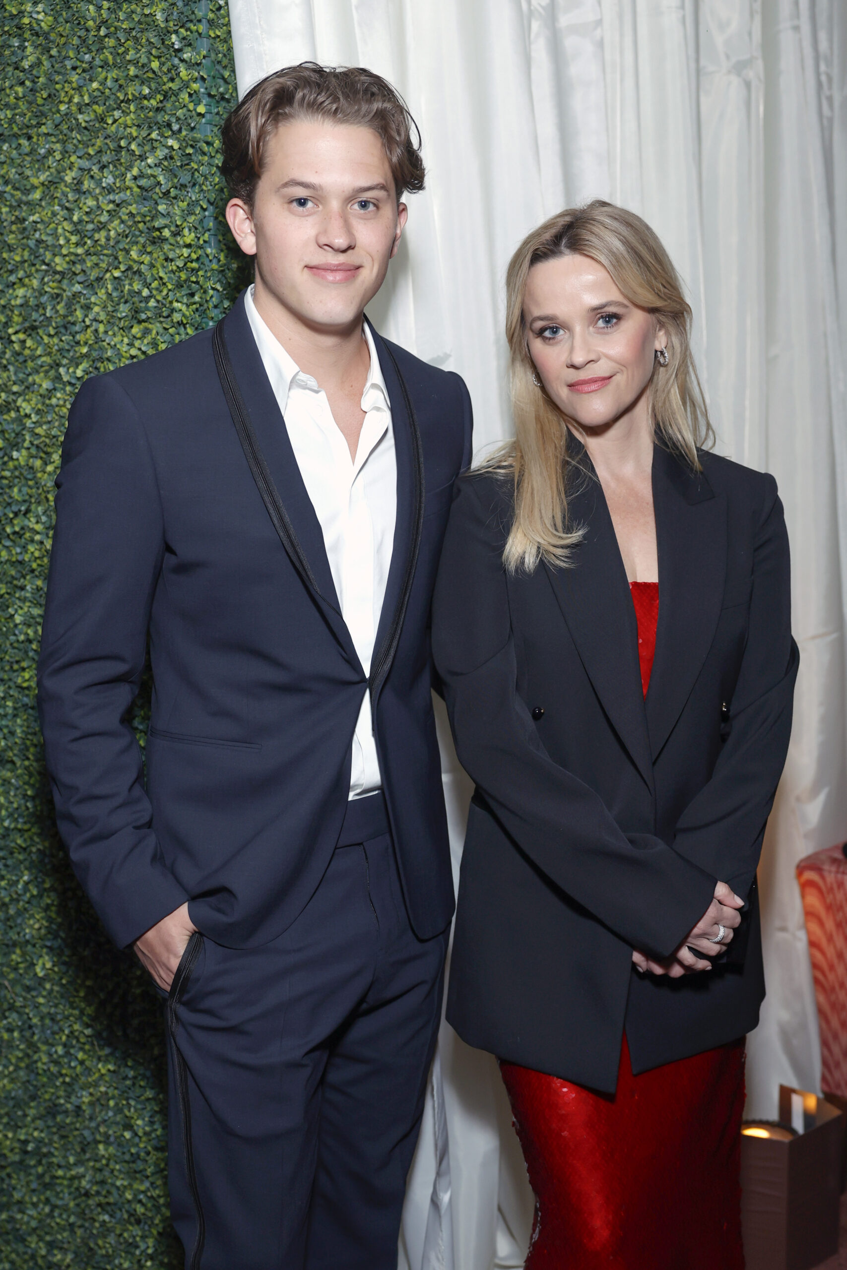 Deacon Reese Phillippe stands beside Reese Witherspoon at a Vanity Fair and Amazon MGM Studios awards season celebration, wearing a navy suit as she opts for a sharp blazer.