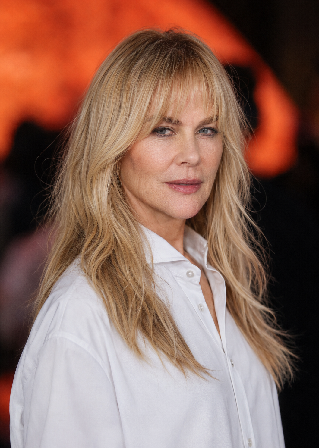 Shifting to the longer blonde hair and wispy fringe of her later eras, this look retains a completely natural skin texture, proving that a modern, stylish look can coexist with realistic creases around the mouth and eyes.