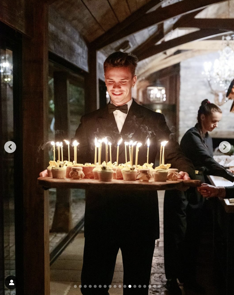 Romeo Beckham holding a tray of cupcakes on his father's 50th birthday celebration, as seen in a photo dated May 4, 2025