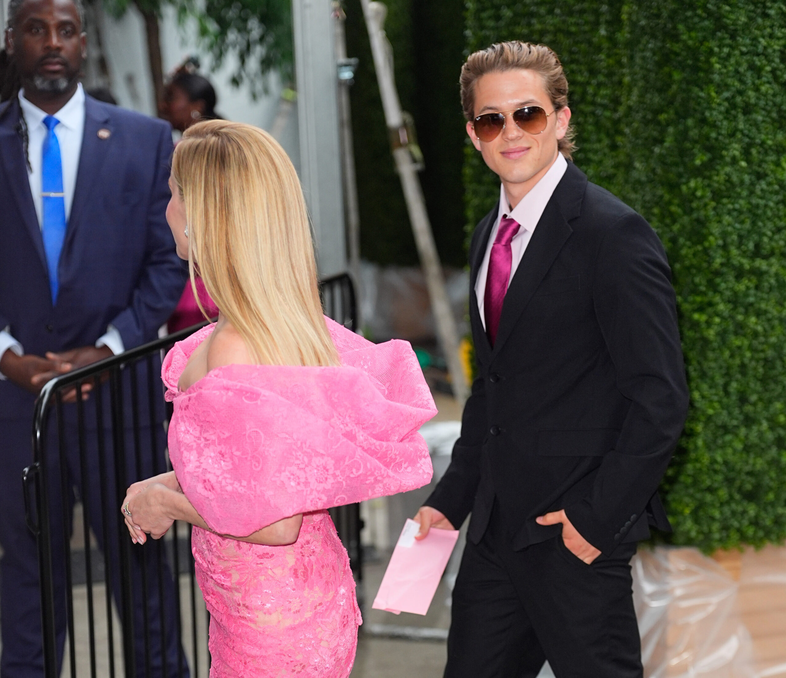 Reese Witherspoon and Deacon Phillippe arrive at the "Elle" premiere in New York City, with her bright pink dress standing out as he smiles in sunglasses and a black suit.