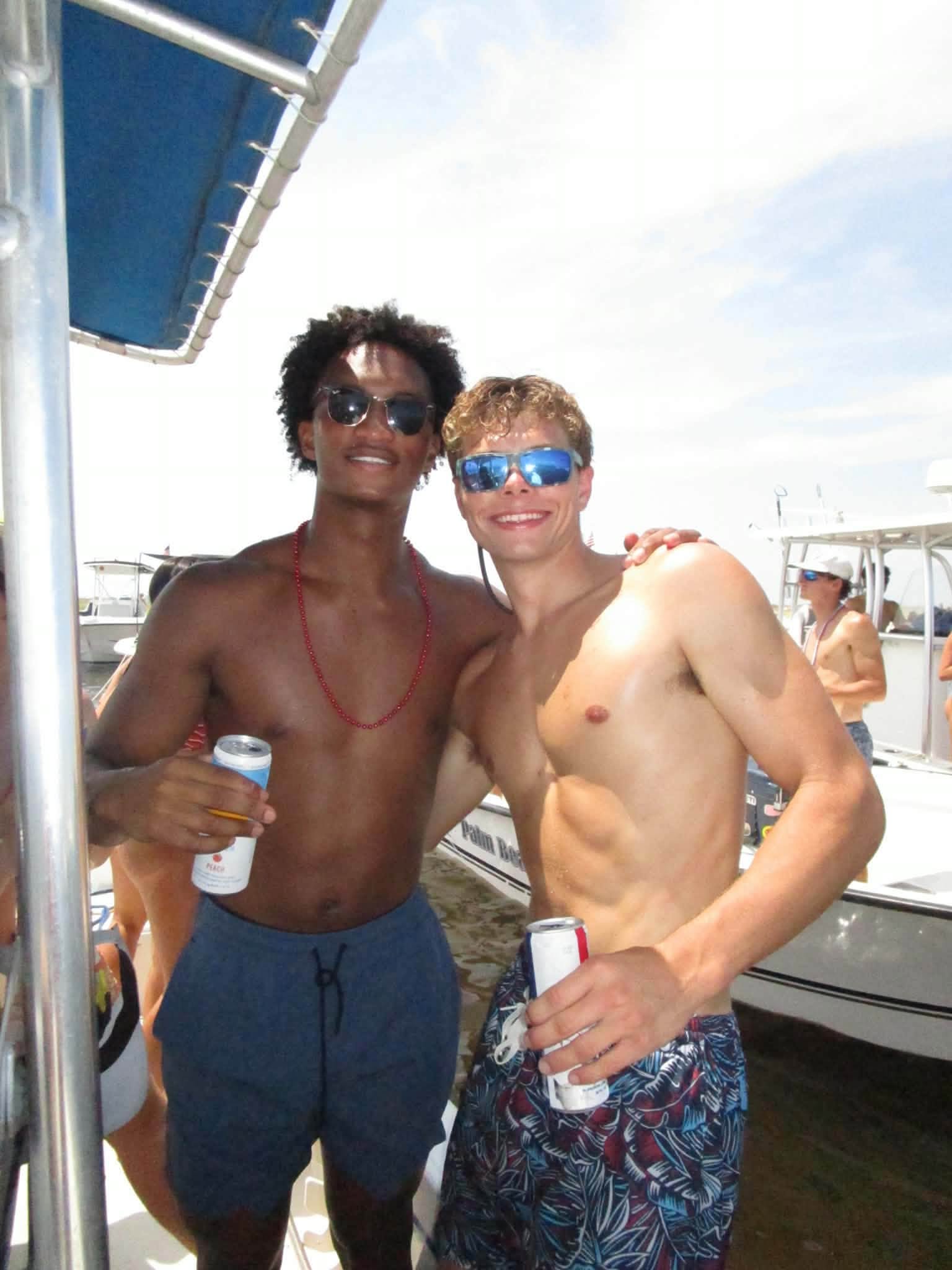 Nolan stands arm-in-arm with a close friend as other holiday boaters pass by in the background. His mother later shared these final snapshots online while addressing the community.