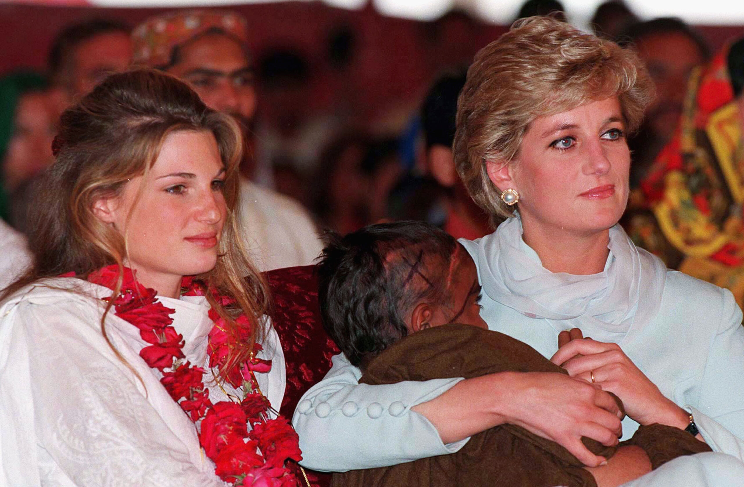 Diana, Princess of Wales, cradles a young cancer patient in her arms beside Jemima Khan during a visit to Shaukat Khanum Hospital on February 22, 1996, in Lahore, Pakistan.