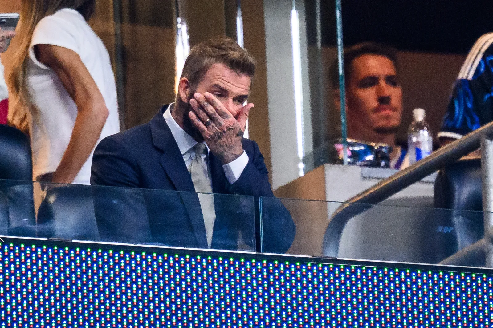 David Beckham is captured in a moment of stress or surprise, covering his mouth during a tense development of the historic final match at MetLife Stadium.