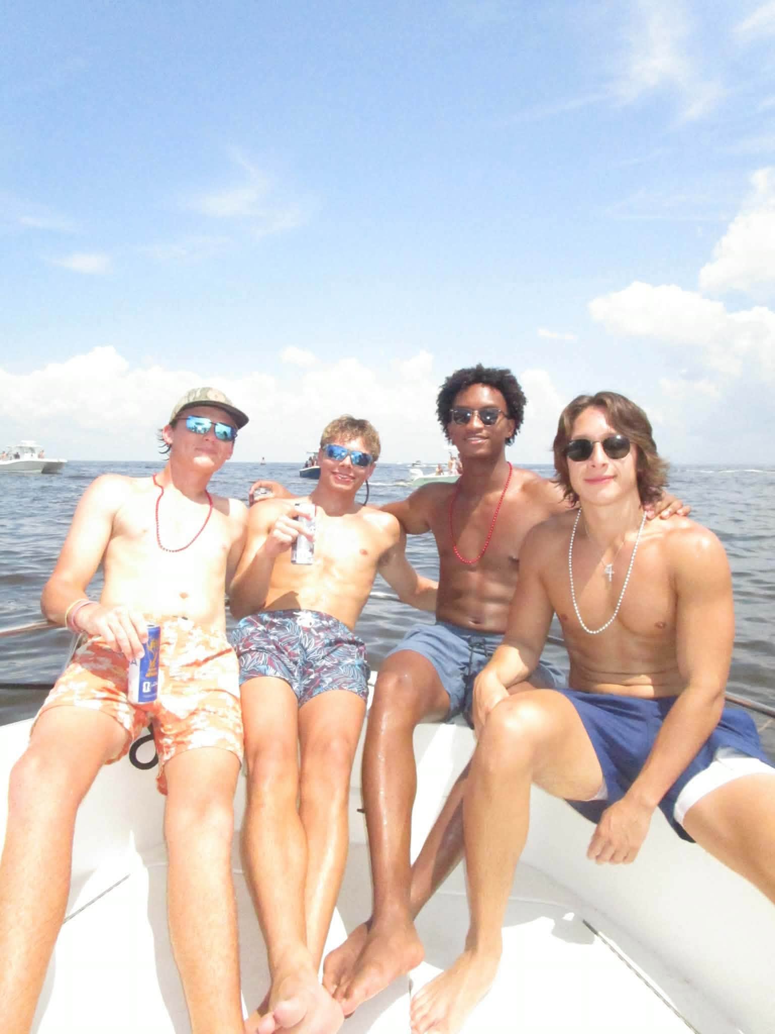 The tragic images show the young player smiling and posing happily with his three friends as they basked inside a boat earlier that day.