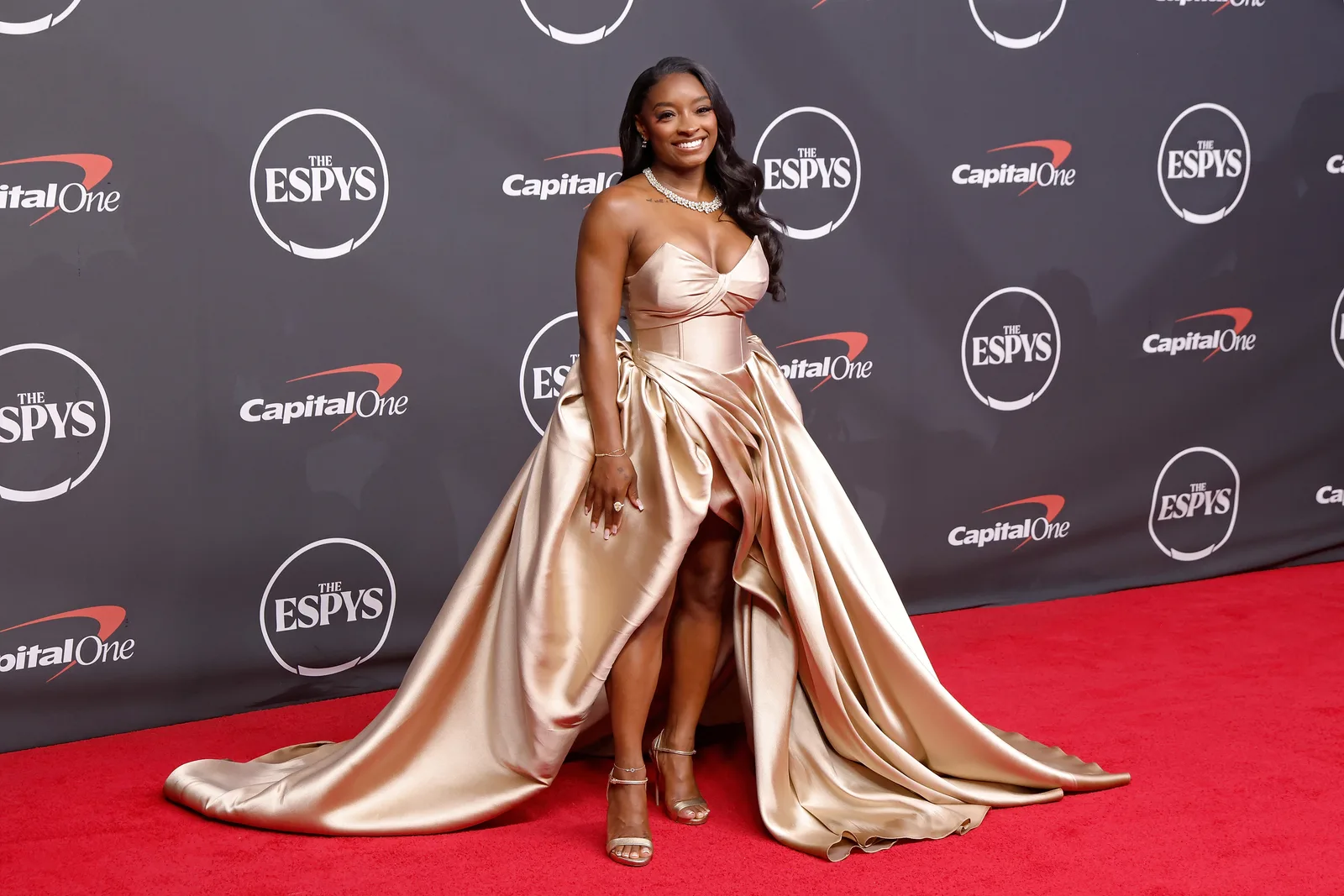 From this angle, the sweeping train takes center stage as Biles poses alone on the carpet. The image captures the fashion moment that many social media users felt deserved as much attention as the viral discussion surrounding Owens.
