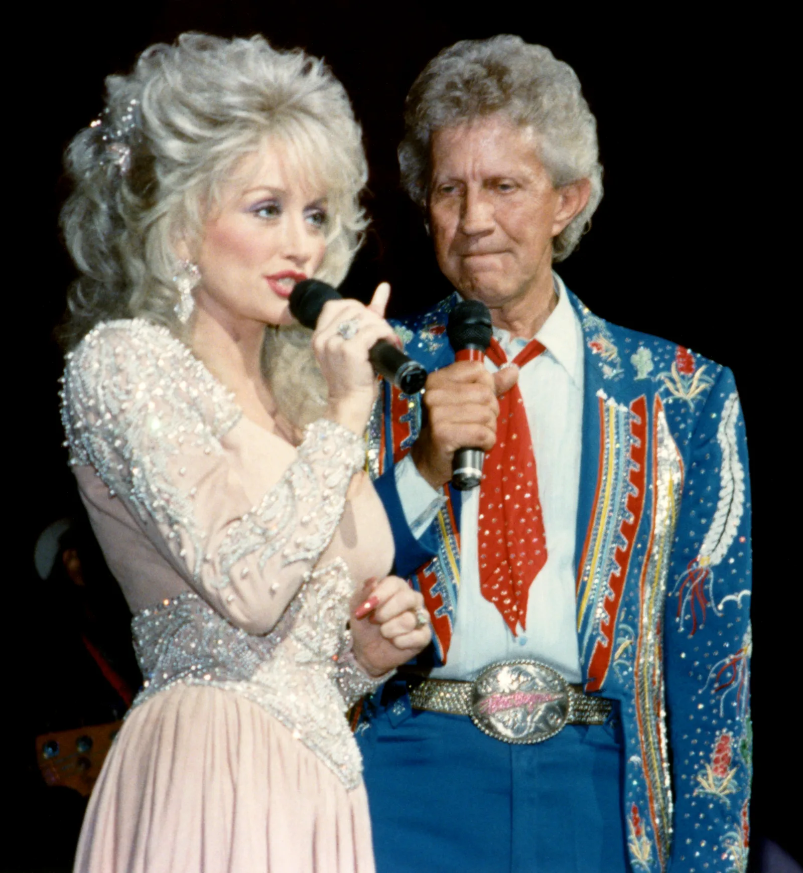 Dolly Parton (1946 - 2026), and Porter Wagoner (1927 - 2007), perform together at the Grand Ole Opry in Nashville, Tennessee, in the 1990s, recalling the professional partnership that helped shape the early years of her remarkable career.