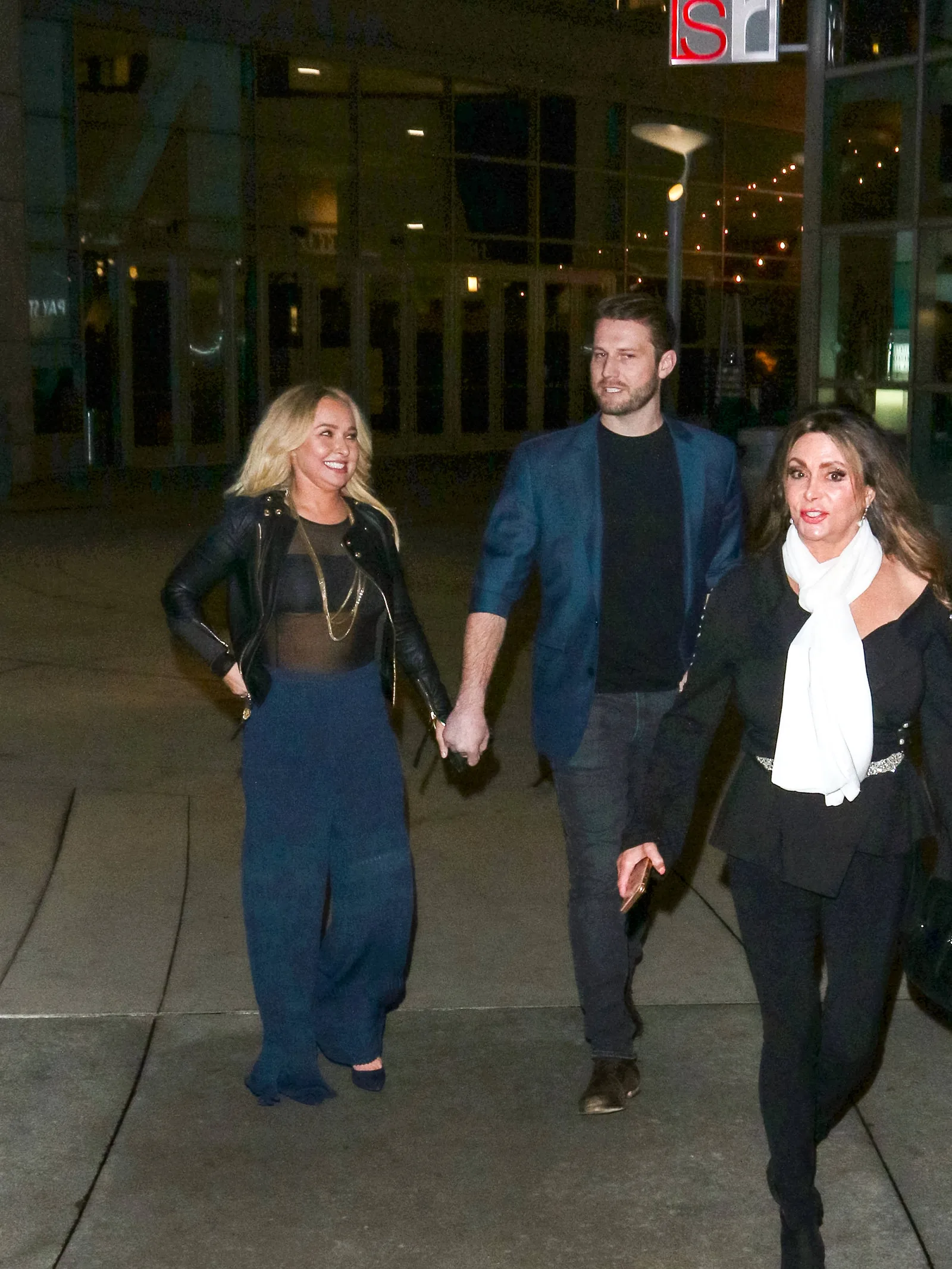 Hayden Panettiere and Brian Hickerson hold hands while walking together in 2019, accompanied by another woman. The couple's relationship later became complicated by Hickerson's legal troubles, with reports revealing they continued communicating despite periods when their romance appeared to have ended publicly.