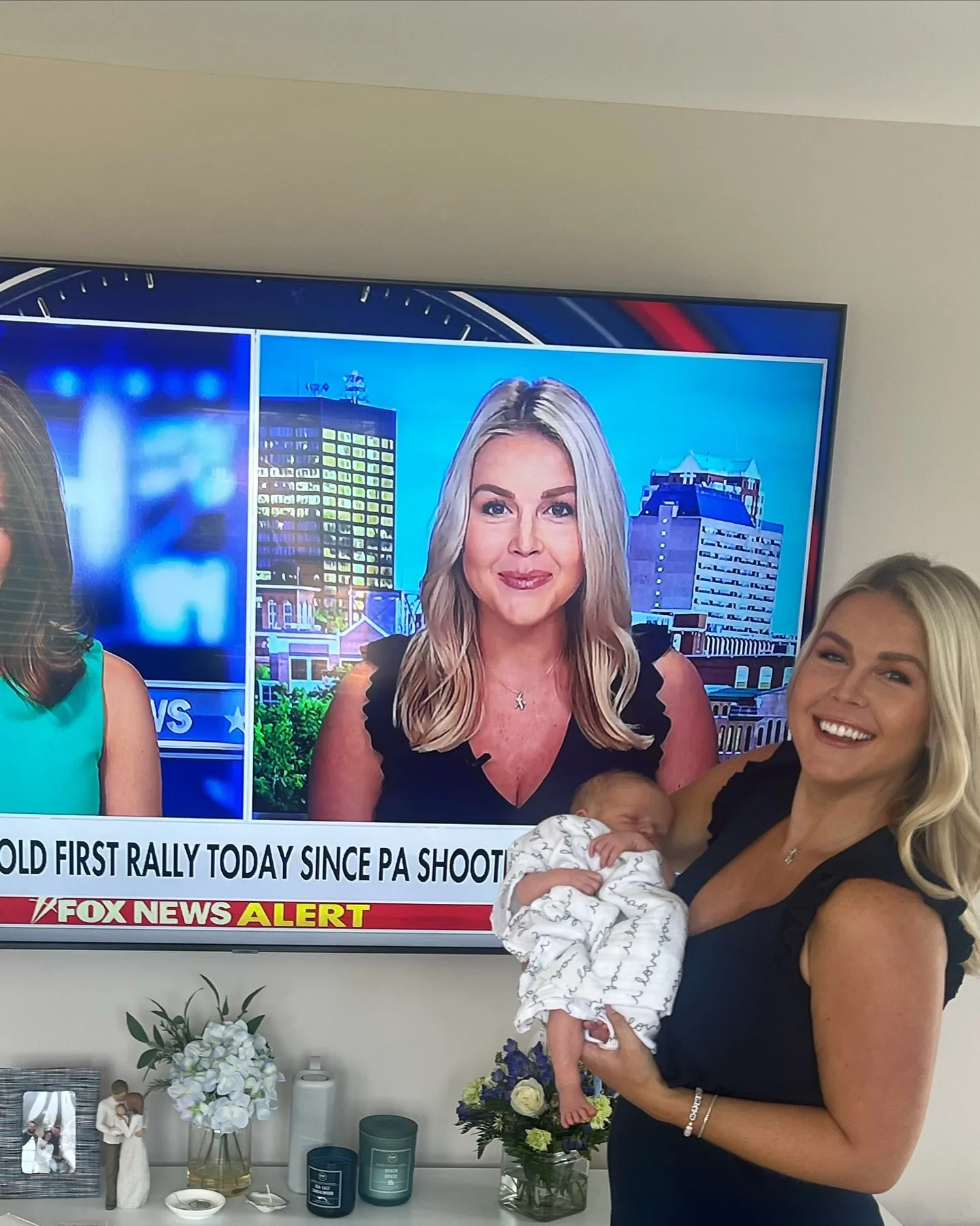 Few images capture Leavitt's overlapping public and private roles quite like this one: she holds her baby while her television persona fills the screen directly behind her. The juxtaposition makes the competing demands she described in her resignation statement especially vivid.