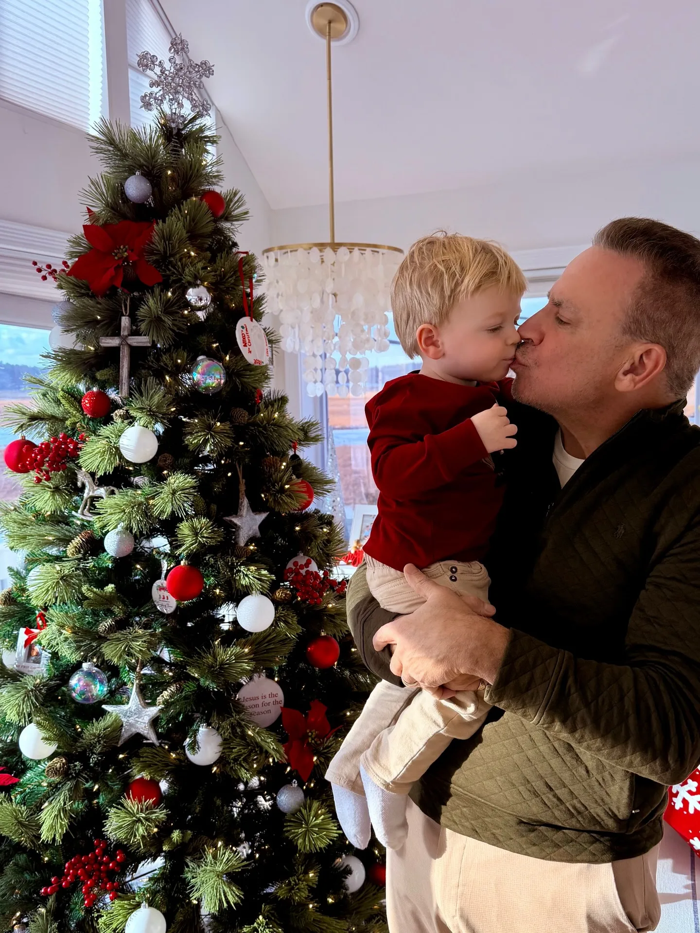 The decorated tree appears again in this father-and-son moment, offering a wider view of the family's holiday setting. Between the bright windows and layered Christmas décor, the Washington residence looks more like a cozy family retreat than the home base of one of the country's most visible political spokespeople.
